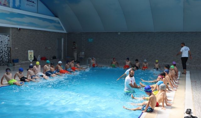Uzman antrenörler eşliğinde çocuklara yüzme eğitimi