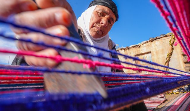Evinin bahçesindeki tezgahta asırlık yöntemle kilim dokuyor